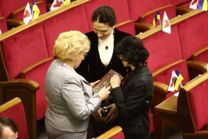 Народні депутатки від партії регіонів Юлія Новікова (по центру) та Ірина Горіна (праворуч) вітають у сесійній залі з 63-річчям ”литвинівку” Катерину Ващук. Дарують їй збірку Вільяма Шекспіра