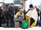 Пятилетний киевлянин Александр с бабушкой вбрасывает деньги в ящик пожертвований для храма