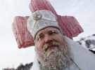 Священик освячує воду біля каплиці в Гідропарку. Його борода та брови вкрилися бурульками
