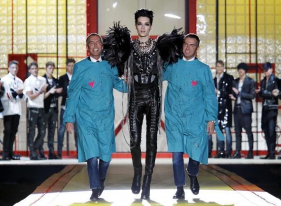 В Милане на Неделе мужской моды 40 дизайнеров представили коллекции осень–зима-2010. Канадские дизайнеры Дин (слева) и Дан с немецким певцом Биллом Каулицом. Они рекомендуют носить смелым модникам одежду, похожую на женскую: узкие брюки, высокие сапоги и 