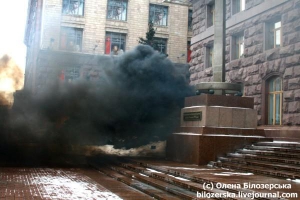 Дым из шашки клубится у входа в мэрию Киева в четверг в полдень. Молодежные организации, которые заявили о нападении, раньше были неизвестны в политической и общественной среде столицы