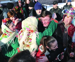 Міністра внутрішніх справ Юрія Луценка (в центрі) обнімає перевдягнений Маланкою Сергій Шваб із села Андрушівка на Житомирщині. Вони беруть участь у фестивалі вертепів у місті Яремча Надвірнянського району Івано-Франківської області. За Луценком у синій ш