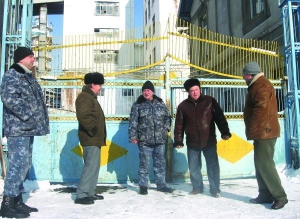 Бывший главный инженер Тальновского сахарозавода Леонид Заболотный (второй справа) разговаривает с охранниками возле проходной предприятия. Работники жалуются, что не получают зарплату уже четвертый месяц