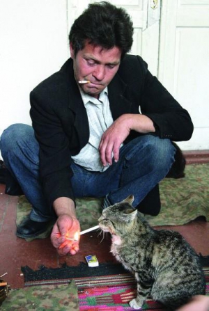 Василий Кит из села Рудка Демидовского района Ривненщины поджигает сигарету коту Матроскину. С домашними животными хозяин разговаривает на французском