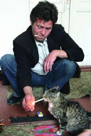 Василий Кит из села Рудка Демидовского района Ривненщины поджигает сигарету коту Матроскину. С домашними животными хозяин разговаривает на французском