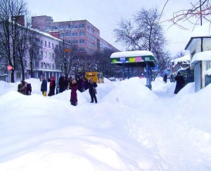 В Черкассах на остановке по улице Благовесной 8 февраля кое-где сугробы достигают человеческого роста. Пассажиры ждут автобусы на дороге