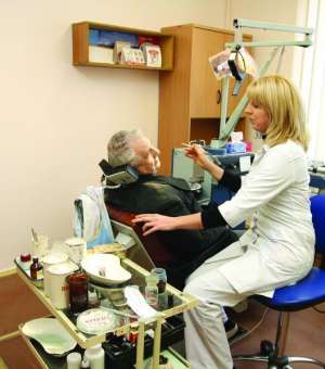 Лікар працює 4 лютого в кабінеті стоматологічної поліклініки Дніпровського району в Києві. Стоматологи переживають, що їхню клініку можуть захопити найближчим часом