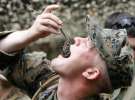 Американский солдат Джон Гарфуд откусывает голову скорпиону, держа его за хвост