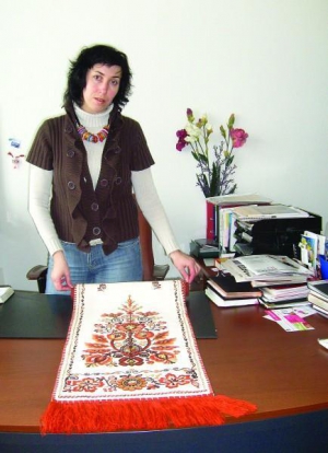 Лариса Теліженко показує рушник, вишитий на домотканому полотні у коричнево-чорній гамі. Такі замовляють на сувеніри за кордон або як подарунок. Коштує  від 1300 гривень