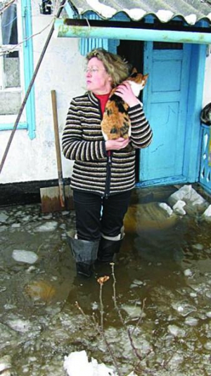 Людмила Марцефей в сапогах у дома на улице Пятихатской в херсонском микрорайоне Остров. В ее доме стоит вода, бытовую технику пришлось вывезти