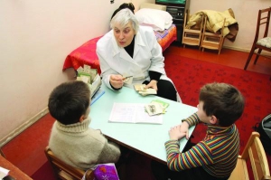 Логопед Ніна Тіліженко в своєму кабінеті в дитячій поліклініці столичного району Березняки вчить дітей правильної вимови. За її спиною стоїть кушетка, на якій вона інколи ночує