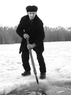 Василий Збираник пешней прорубает полынью на реке Сухой Кагамлик в селе Бабичивка на Глобинщине. Толщина льда здесь достигает 40 сантиметров. Из-под льда пахнет затхлым