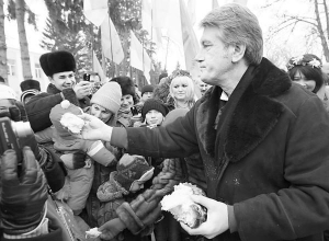 Екс-президент Віктор Ющенко пригощає подарованим йому короваєм жителів села Моринці на Черкащині 9 березня