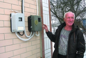 Житель села Кобриново Тальновского района Николай Данильченко показывает на стене своего дома два электросчетчика. Один из них — двухтарифный. Учитывает использованную электрокотлом энергию