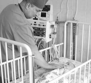 Завідувач реанімаційного відділення Полтавської міської дитячої лікарні Микола Рева оглядає скалічену двомісячну дівчинку. У дитини мозкова кома