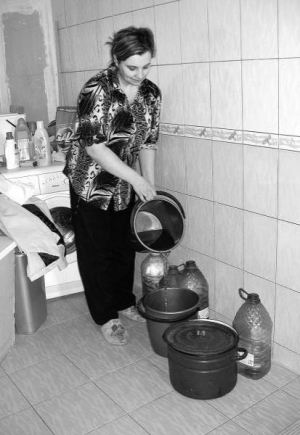 Жительница дома 38а по улице Скалецкого в Виннице Елена Ковальская набирает воду в ведра и пластиковые бутылки. Из-за плохого давления часто пропадает вода