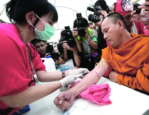 Буддийский монах в Таиланде сдает кровь для акции протеста. У каждого участника забирали по 200 миллиметров