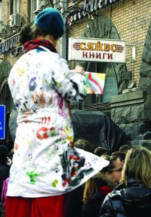 Киевский художник Валерий Голейко рисует картину ”Сяйво” возле книжного магазина ”Сяйво”. На полотне изобразил солнце, которое обступают черные тучи