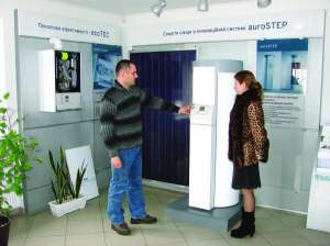 Менеджер по продаже Виктор Данильченко показывает посетительнице гелевую установку ”Ауро степ”, предназначенную для нагрева воды
