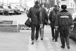 Милиционер ведет в Подольский райотдел в среду вечером троих киевлян. Они пили пиво на столичной площади Контрактовой. У мужчины слева в руках — жестяная банка пива
