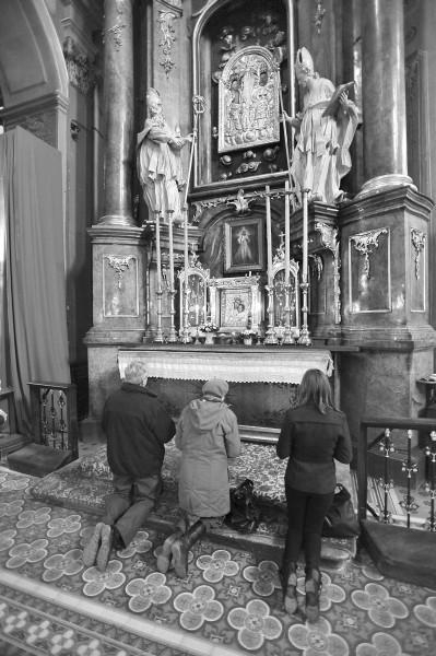 У Латинському катедральному соборі Львова біля вівтаря моляться парафіяни, які щойно посповідалися. Ксьондз наклав на них покуту за скоєні гріхи