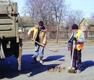 Працівники ”Комбінату благоустрою і озеленення” Валерій Гонков (ліворуч) та Ігор Ткаченко латають сумішшю глини та битої цегли вулицю Гурамішвілі в Миргороді на Полтавщині