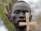 Християнин із Південного Судану тримає хрест під час молитви. Він воює з суданцями на півночі країни, бо не хоче приймати іслам