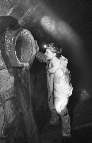 Диггер Андрей Риштун во львовском подземелье показывает трубу, по которой в центральный коллектор стекают нечистоты