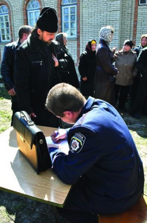 Міліціонер із Липовецького райвідділу бере свідчення у настоятеля храму Павла Кучерука. Священик розказує, як його били. Тримається за серце. Під час бійки йому стало зле. Попід стінами храму стоять вірянки, які підтримують Київський патріархат