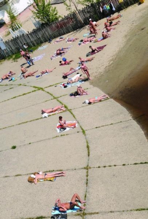 Люди загорають біля Дніпра. У столичному Гідропарку неофіційний пляжний сезон відкрили у перших числах травня, коли на вулиці потепліло до 26 градусів