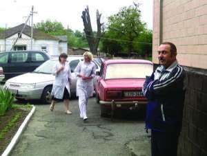 Валентин Майборода (на фото справа) у входа в Тальновскую районную больницу. Он лежит с воспалением легких уже 10 дней. Говорит, так тяжело заболел впервые в жизни