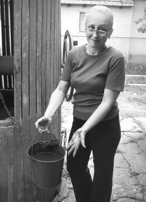 Еріка Шарінська з села Мужієво Берегівського району Закарпаття показує брудні від іржі відро та руки. Через насичену важкими металами воду, відро жінці доводиться міняти тричі на рік