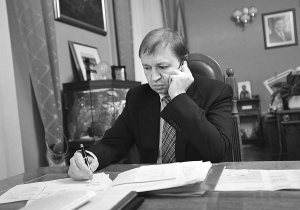 Губернатор Львовщины Василий Горбаль разговаривает по телефону в своем рабочем кабинете во вторник в 21.30. Сзади него стоит большой аквариум. На стене под портретом президента — икона Богородицы