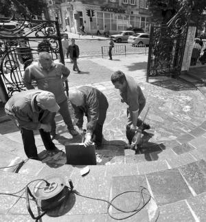 Бригада ремонтников заменяет поврежденную плитку на ступеньках при входе во двор национального университета ”Львовская политехника” в среду, в канун визита президента Виктора Януковича