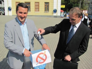 Бывший консул Польши в Виннице Анджей Сломский 31 мая бросает пачку с тремя сигаретами в пакет для мусора на площади Театральной
