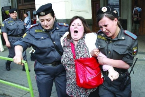 Две работницы ОМОНа задерживают участницу уличной акции российской оппозиции Марш несогласных в Москве. На митинг вышло около 450 человек, 130 из них задержали