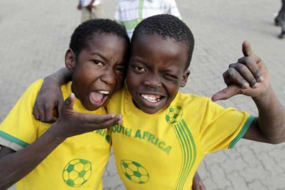Два мальчика из южноафриканского города Йоханнесбург позируют после игры между детскими командами на стадионе ”Александра” в центре города