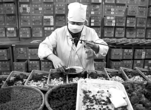 Фармацевт аптеки при лікарні Пекінського університету в Китаї готує суміш лікарських трав.  Їх застосовують замість лікування та вакцинування проти грипу