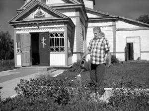 Настоятель храма Покровы Пресвятой Богородицы в селе Городецкое Уманского района Николай Соловей поливает клумбы около церкви. Цветники есть почти в каждом дворе села