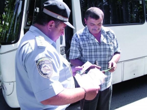 Інспектор Тальнівського відділення Державтоінспекції  Леонід Заграничний (ліворуч)  перевіряє документи у водія автобуса  Черкаси— Умань