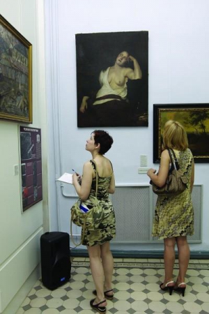 У Національному художньому музеї відвідувачки розглядають картини із колекції ”Градобанку”. У центрі висить полотно невідомого німецького художника ”Оголена”