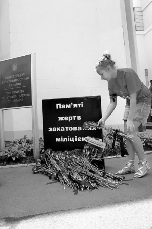 Участница инициативной группы "Понимаем права человека" кладет гвоздику у символической стелы у входа в здание Министерства внутренних дел 25 июня 