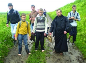 Виктор Пидгирный (слева), Иван Черний и отец Михаил Забанджала на богомолье в Зарваницу идут босиком. Так легче двигаться. Главное — не наступить на колючку