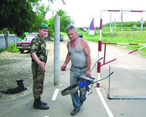 Юрій Тютюнник з хутора Висілки на Донеччині переносить садовий реманент через українсько-російський кордон. Прикордонна смуга проходить через його земельну ділянку