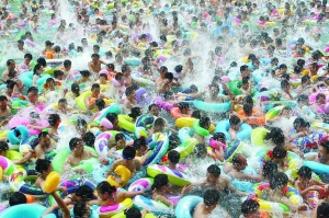 Жители округа Суйнин Сычуанской провинции на юге Китая охлаждаются в бассейне