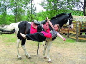 У таборі ”Козацька фортеця” за селом Великий Перевіз Шишацького району на Полтавщині 11-річна киянка Валерія Побокіна робить трюки на коні Техасові. Вона тут навчилася їздити верхи