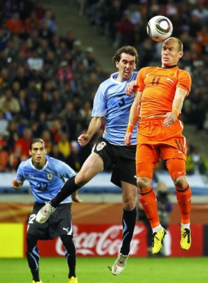 Форвард голландців Арієн Роббен (№11) випереджає захисника збірної Уругваю Дієго Годіна