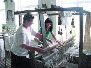 Екскурсовод Галина Дзюба (ліворуч) у музеї села Зелена Діброва Городищенського району показує туристці з Черкас, як ткали у старовину рядна