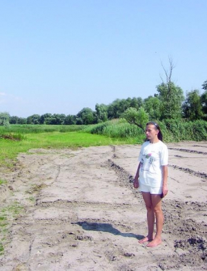 София Денисенко из Дахновки стоит на месте бывшего пруда, который выкопали местные жители. На днях его засыпали под строительство