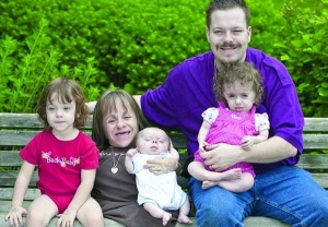 Американка Стейсі Геральд (посередині) з чоловіком Віллом і трьома дітьми. Стейсі має зріст 71 сантиметр. У неї крихкі кістки, не ростуть кінцівки і не розвиваються легені